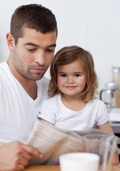 Отец читает газету со своей дочерью — стоковое фото