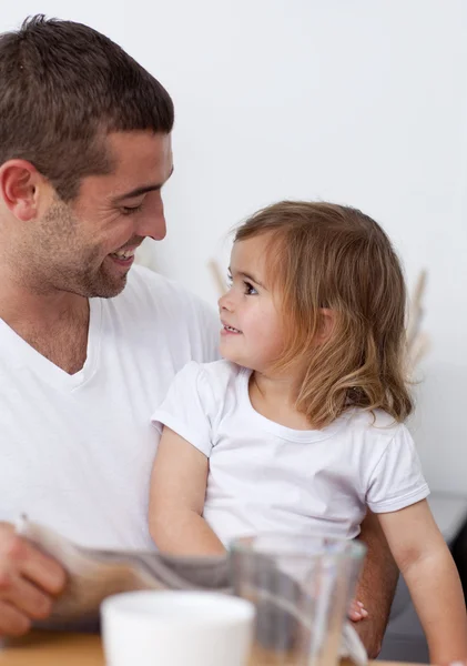 Pappa läser en tidning leende till sin dotter — Stockfoto