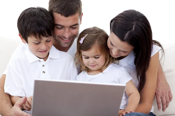 Família jovem usando um laptop em casa — Fotografia de Stock