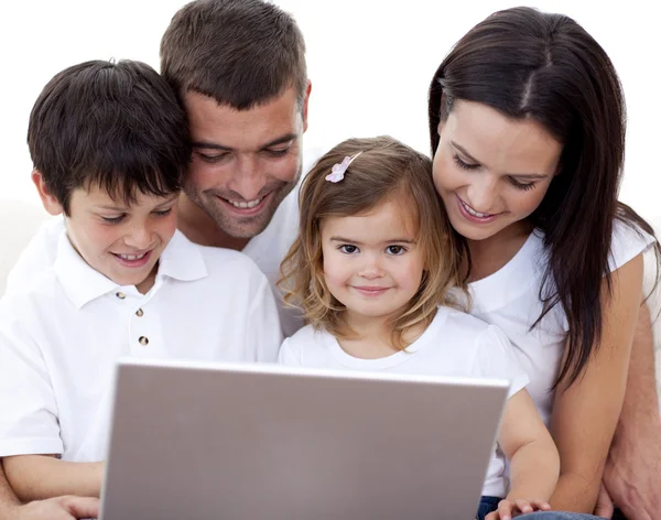 Felice giovane famiglia utilizzando un computer portatile a casa — Foto Stock