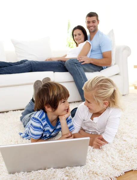Amigos usando um laptop e casal no sofá — Fotografia de Stock