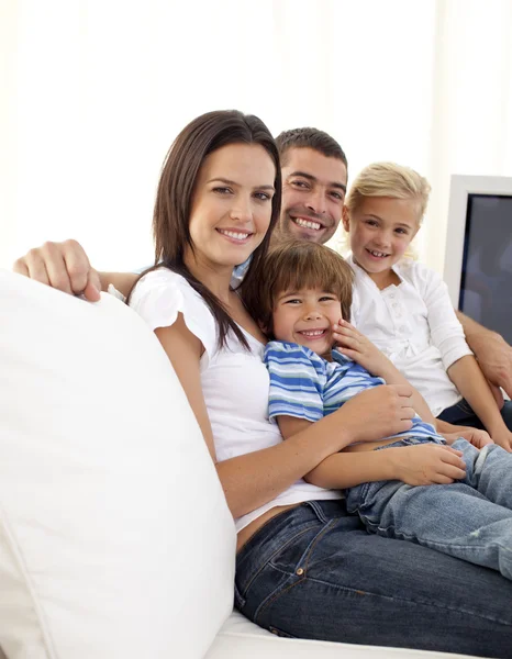 Glada föräldrar och barn sitter på sof — Stockfoto