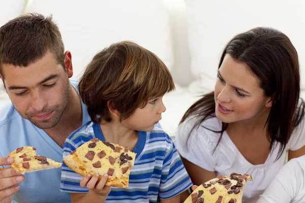 Prents and son eating pizza in living-room — Stock Photo, Image