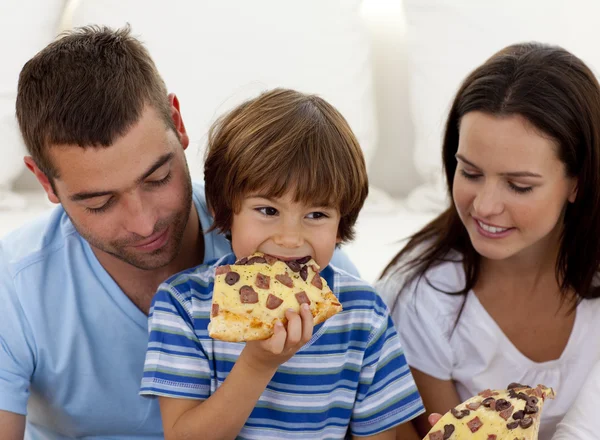 Happy boy eating pizza with ihs parents — Stock Photo, Image