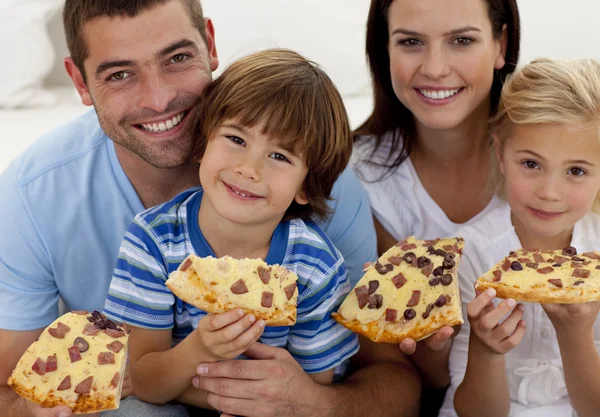 Retrato de família comer pizza no sofá — Fotografia de Stock