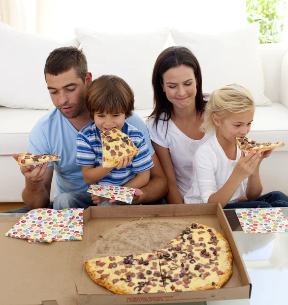 Familie isst Pizza im Wohnzimmer — Stockfoto