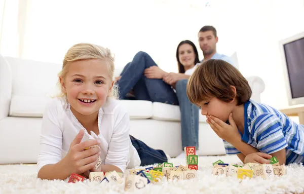 Kinder spielen zu Hause mit Buchstabenwürfeln — Stockfoto