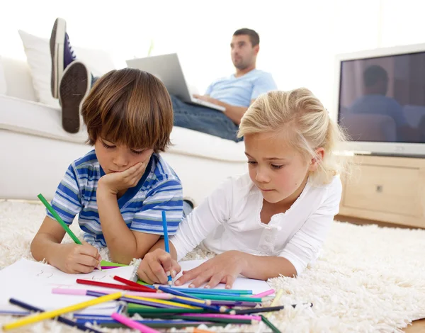 Niños pintando en la sala de estar y padre usando una computadora portátil —  Fotos de Stock
