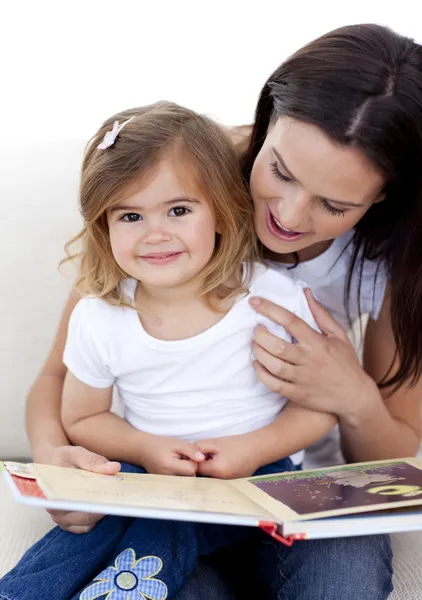 Lilla flickan läsa en bok withher mamma — Stockfoto