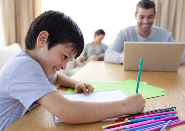 Jongen tekening en ouders thuis werken — Stockfoto