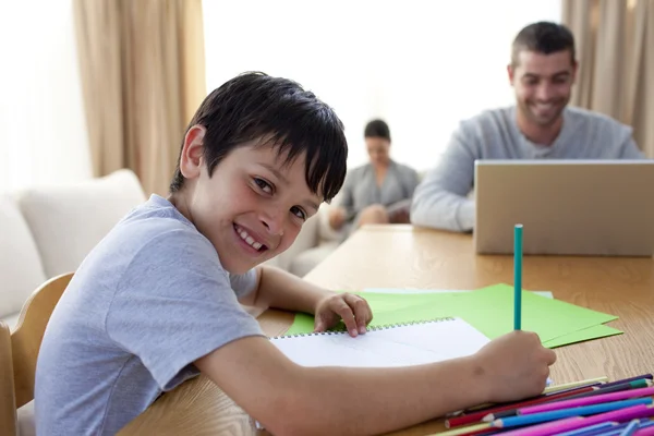 Jongen schilderen en vader met behulp van een laptop en een moeder lezen — Stockfoto