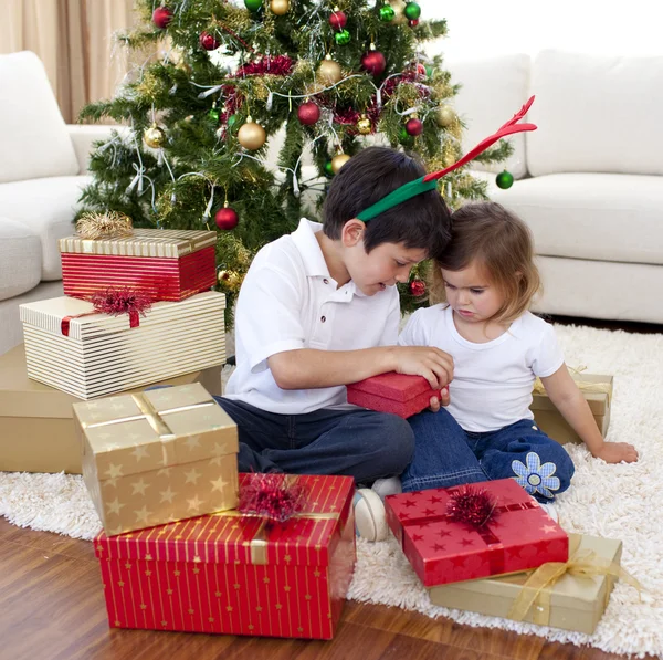 Šťastný bratr a sestra otevírání vánoční dárky — Stock fotografie