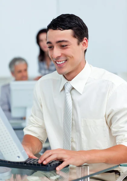Hombre de negocios alegre trabajando en una computadora Imagen de stock