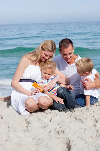 Smiling mother with her family holding sunscreen Stock Image
