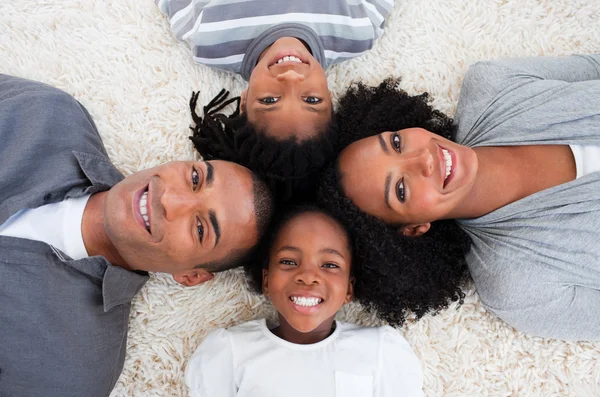 Afro-American family on floor with heads together — Stock Photo, Image