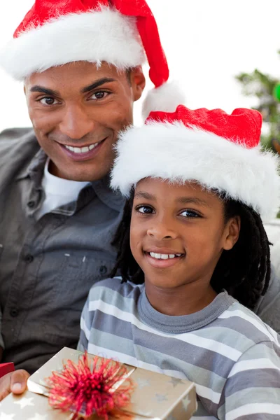 Retrato de un padre y un hijo afroamericanos celebrando una Navidad Imagen De Stock