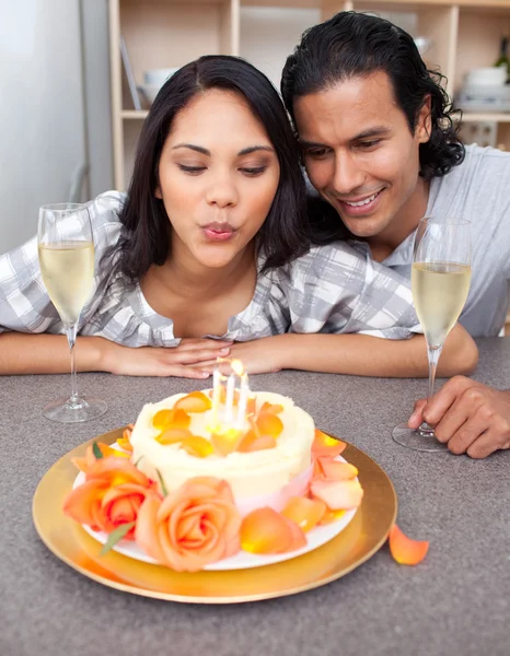 Mooie vrouw opblazen van kaarsen met haar echtgenoot voor haar birthda Stockfoto