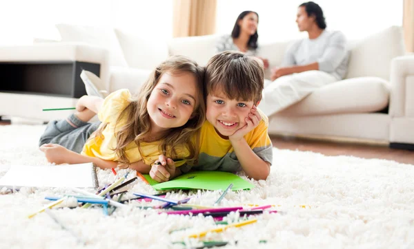 Adorable btother and sister drawing lying on the floor — Stock Photo, Image