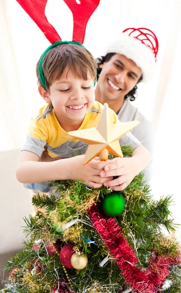 父と息子は、クリスマス ツリーを飾ること ストックフォト