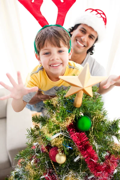 Vader en zoon versieren van een kerstboom Rechtenvrije Stockafbeeldingen