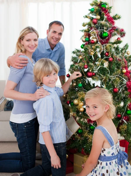 Portret van een jong gezin versieren van een kerstboom Rechtenvrije Stockafbeeldingen