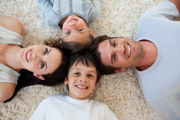 Happy family lying on the floor — Stock Photo, Image