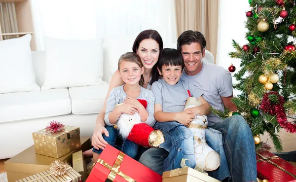 Happy family at Christmas time holding lots of presents Royalty Free Stock Images
