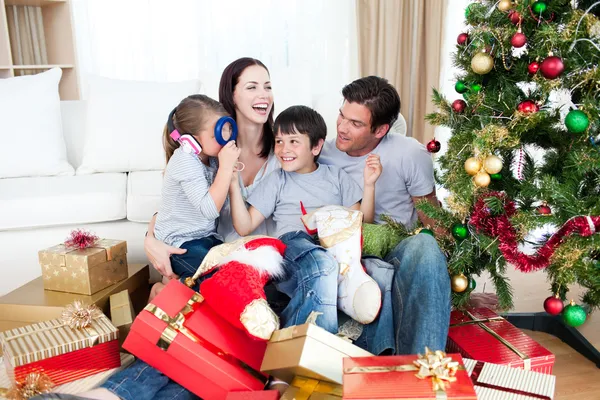 Lycklig familj spelar med julklappar Stockbild