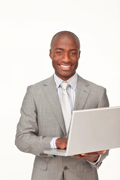 Uomo d'affari afro-americano che utilizza un computer portatile e sorride Immagini Stock Royalty Free