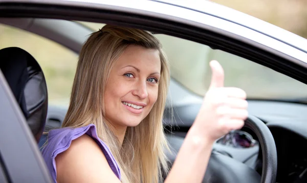 Lächelnde Autofahrerin mit erhobenem Daumen lizenzfreie Stockfotos