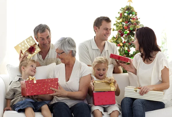Familia feliz en casa abriendo regalos de Navidad Imagen de archivo