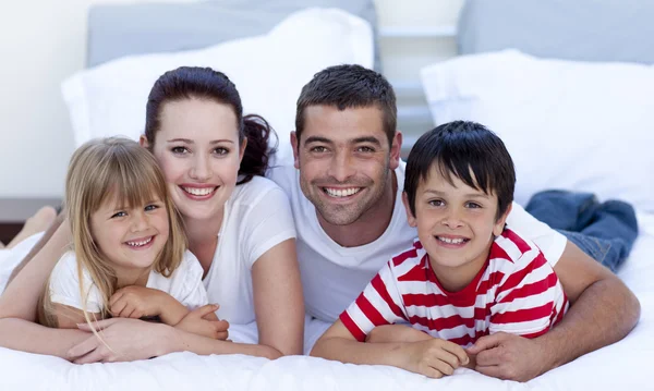 Porträt einer Familie, die zusammen im Bett liegt lizenzfreie Stockfotos
