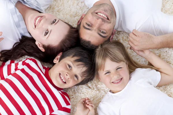 Family on floor with heads together — Stock Photo, Image