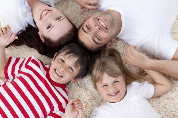 High angle of family on floor with heads together — Stock Photo, Image