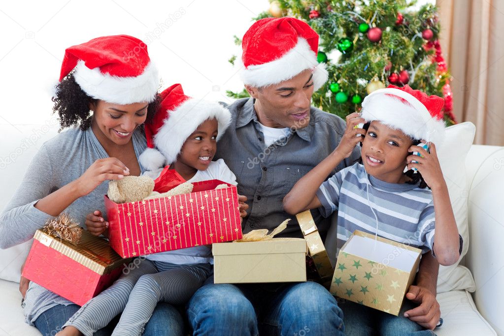 Download - Happy Afro-American family playing with Christmas presents at ho...