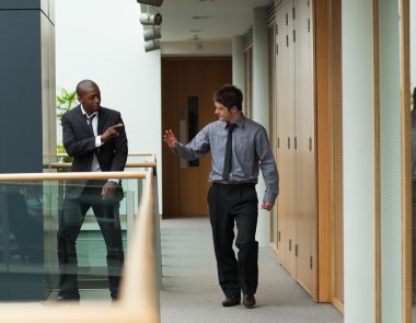 Businessmen saying goodbye in a corridor clipart