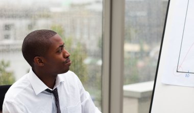 Afro-American businessman looking at a whiteboard clipart