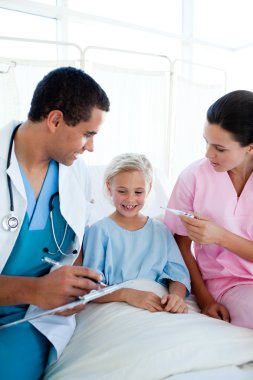 A nurse taking her patient's temperature in a hospital clipart