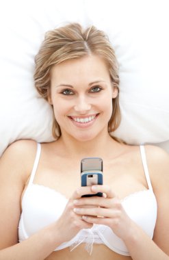 Happy woman in underwear sending a text clipart