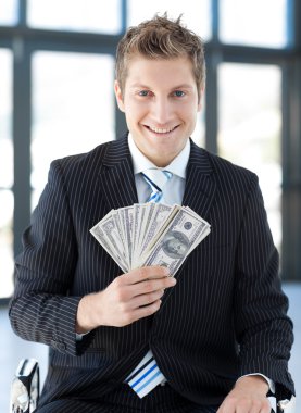 Businessman holding dollars clipart