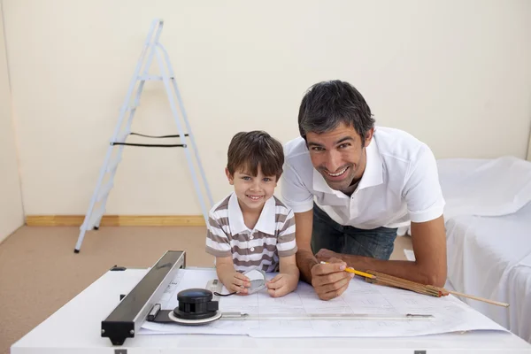 Отец и сын рисуют архитектурные планы — стоковое фото
