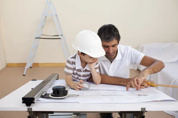 Père et fils étudient le travail avec des plans — Photo