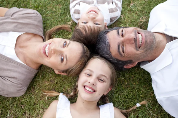 Happy family lying in a park — Stock Photo, Image