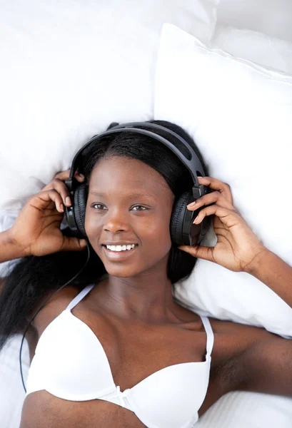 Onu yatakta yatarken radyant kadın müzik dinleme — Stok fotoğraf