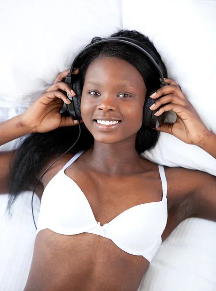 Heldere vrouw in ondergoed luisteren muziek — Stockfoto