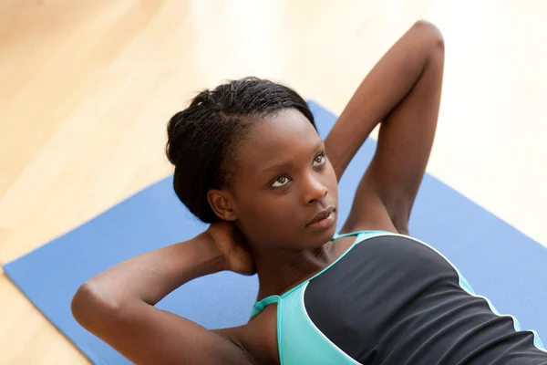 Mujer étnica joven en ropa de gimnasio haciendo ejercicio — Foto de Stock