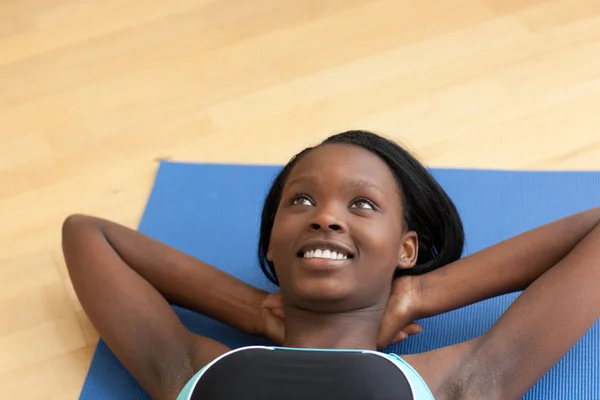 Mujer sonriente en ropa de gimnasio haciendo abdominales —  Fotos de Stock