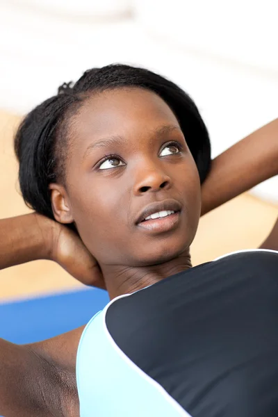 Ethniic kvinna i gym outfit gör sit-ups — Stockfoto