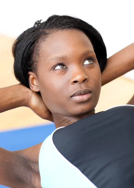 Koncentrerad kvinna i gym kläder utövar — Stockfoto