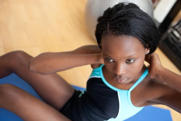Mujer étnica seria en ropa de gimnasio haciendo ejercicio —  Fotos de Stock